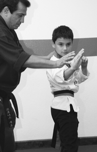 Master Corona working with a young student on stance fundamentals